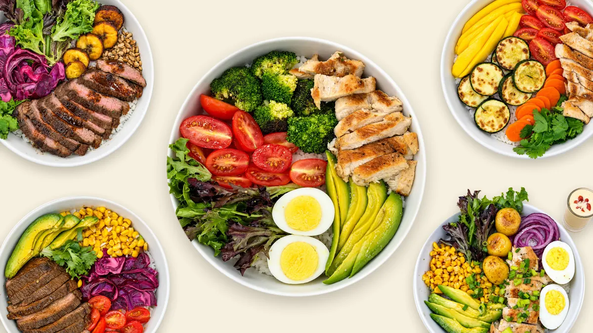 Five VIVA Bowls seen from above on a cream table: Golden chicken quinoa, Pacific mango chicken, Farmhouse, Caribbean plantain beef and Mexican beef bowls